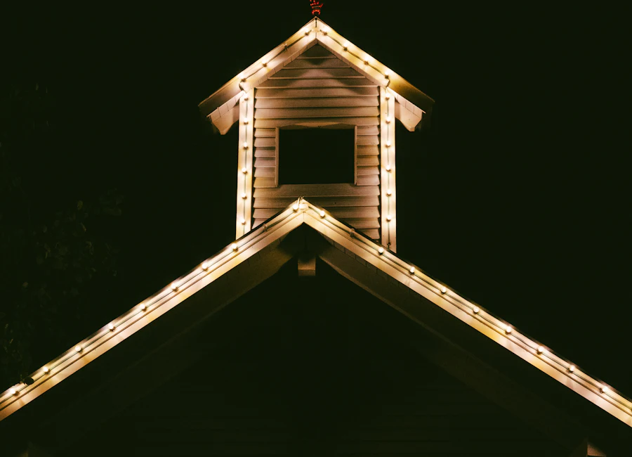 Torre de igreja iluminada por luzes de festa à noite